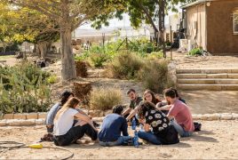 group of alumni sitting in circle outdoors