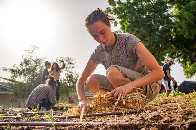 female student working in vegetable garden