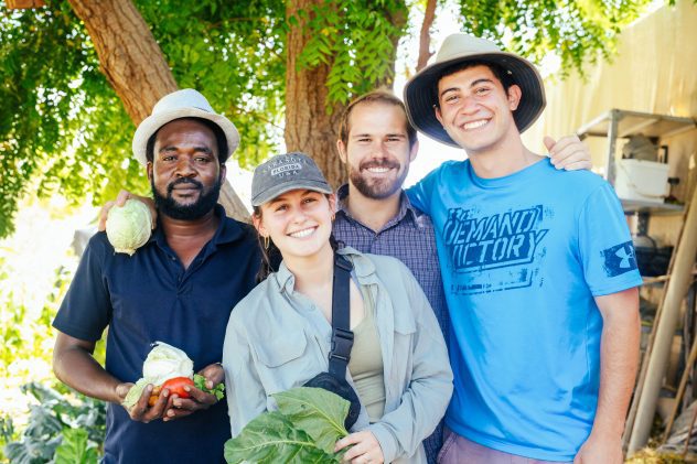 4 smiling students in the garden